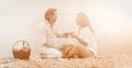 Romantic picnic on seashore. Man and woman have conversation drinking red wine. Mature couple sits on sand looking to Royalty Free Stock Photo