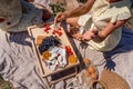 Romantic picnic for two with fruit, bread and cheese. Oranges, cherries, black grapes and camembert on a wooden