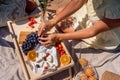 Romantic picnic for two with fruit, bread and cheese. Oranges, cherries, black grapes and camembert on a wooden table