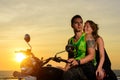 Romantic picture with a couple of beautiful stylish bikers at sunset. Handsome guy with tatoo and young sexy woman enjoy