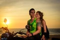 Romantic picture with a couple of beautiful stylish bikers at sunset. Handsome guy with tatoo and young sexy woman