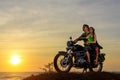 Romantic picture with a couple of beautiful stylish bikers at sunset. Handsome guy with tatoo and young sexy woman Royalty Free Stock Photo