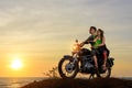 Romantic picture with a couple of beautiful stylish bikers at sunset. Handsome guy with tatoo and young sexy woman Royalty Free Stock Photo