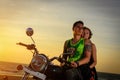 Romantic picture with a couple of beautiful stylish bikers at sunset. Handsome guy with tatoo and young sexy woman enjoy