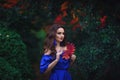 Romantic portrait of a beautiful young girl with blue makeup and red lips, in a long ultramarine blue dress with long blue earring Royalty Free Stock Photo