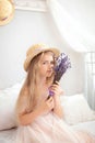 Romantic portrait charming young blonde girl in straw hat. Little girl with a bouquet of summer flowers in home. Childhood concept Royalty Free Stock Photo