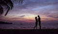 Romantic portrait of a couple hugging on a tropical brach - sunset circumstance
