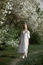 Romantic portrait of a girl in the park near a blooming apple tree. Natural cosmetics. Natural beauty of a woman in a white dress Royalty Free Stock Photo