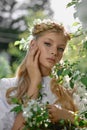 Romantic portrait of a girl in the park near a blooming apple tree. Natural cosmetics. Natural beauty of a woman in a white dress Royalty Free Stock Photo