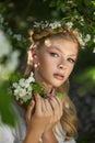 Romantic portrait of a girl in the park near a blooming apple tree. Natural cosmetics. Natural beauty of a woman in a white dress Royalty Free Stock Photo