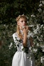 Romantic portrait of a girl in the park near a blooming apple tree. Natural cosmetics. Natural beauty of a woman in a white dress Royalty Free Stock Photo