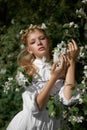 Romantic portrait of a girl in the park near a blooming apple tree. Natural cosmetics. Natural beauty of a woman in a white dress Royalty Free Stock Photo