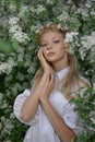 Romantic portrait of a girl in the park near a blooming apple tree. Natural cosmetics. Natural beauty of a woman in a white dress Royalty Free Stock Photo