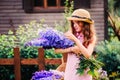 Romantic portrait of happy child girl picking bouquet of beautiful blue delphinium flowers Royalty Free Stock Photo