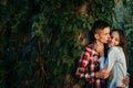 Romantic portrait of the loving couple. Handsome young man is kissing his beautiful girlfriend with charming smile in Royalty Free Stock Photo