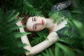 Romantic portrait of a woman in a fern in the forest. Art woman natural makeup resting in nature. Green fern thickets