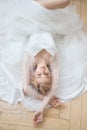 Romantic portrait of a woman on the floor in a beautiful long white dress. The girl is blonde with blue eyes and beautiful makeup Royalty Free Stock Photo