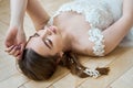 Romantic portrait of a woman on the floor in a beautiful long white dress. The girl is blonde with blue eyes and beautiful makeup Royalty Free Stock Photo