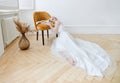Romantic portrait of a woman on the floor in a beautiful long white dress. The girl is blonde with blue eyes and beautiful makeup Royalty Free Stock Photo