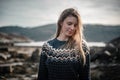 Romantic portrait of young blonde woman smiling and posing next to a fjord on a beautiful sunny spring day Royalty Free Stock Photo