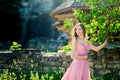 Romantic portrait of young woman in airy pink dress on a countryside background