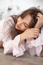 Romantic portrait of young woman in pink cotton dress with puffy sleeves resting her head on her hands. Eco-friendly.