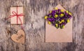A romantic premise, an envelope with flowers, a gift and a wooden heart. St. Valentine`s Day. Royalty Free Stock Photo