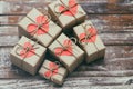 Romantic presents set. Gift boxes wrapped in brown craft paper and tie hemp string. Carton hearts. Decorative wood background. Royalty Free Stock Photo