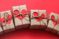 Romantic presents set. Gift boxes wrapped in brown craft paper and tie hemp string. Carton hearts. Red solid background. Royalty Free Stock Photo