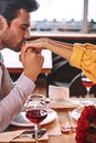 Romantic proposal. Young man kisses hands of his girlfriend