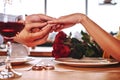 Romantic proposal. Young man wearing ring on hands of his girlfriend