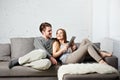 Romantic relaxed young couple using tablet computer on sofa Royalty Free Stock Photo