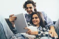 Romantic relaxed young couple using tablet computer on sofa at home Royalty Free Stock Photo