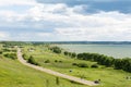 Romantic road into the distance, horizon, lake and green flat plain. Royalty Free Stock Photo
