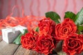 Romantic Saint Valentine card with bouquet of beatiful red roses and a present box Royalty Free Stock Photo
