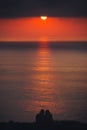 Romantic scene of couple watching beautiful sea at sunset