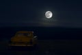 Romantic scene of old vintage car with couple inside and Moon on sky at night. Silhouette love and car on Full Moon Background. Se Royalty Free Stock Photo