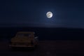 Romantic scene of old vintage car with couple inside and Moon on sky at night. Silhouette love and car on Full Moon Background. Se Royalty Free Stock Photo