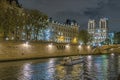 Romantic Scene in Paris at Night With Boat on Seine River Notre Dame Cathedral and Stone Buildings Royalty Free Stock Photo