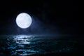 Romantic and scenic panorama with full moon on sea to night. Table decoration with moon miniature and water Royalty Free Stock Photo