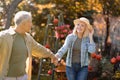 Romantic senior couple holding hands and walking in the park on warm autumn day, happily retired, free space Royalty Free Stock Photo