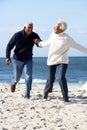 Romantic Senior Couple Running Along Beach Royalty Free Stock Photo