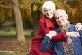 Romantic Senior Couple Sitting On Fence In Autumn Woodland Royalty Free Stock Photo