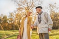 Romantic senior couple walking in beautiful autumn city park, holding hands Royalty Free Stock Photo