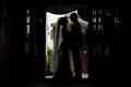 Romantic, sensual newlywed couple silhouettes hugging in doorway