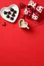 Romantic set: heart shaped candy dish, coffee in heart shaped cup, gift box on red background. Valentines Day concept. Top view Royalty Free Stock Photo