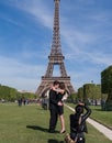 A couple takes a photo in front of the Eiffel Tower in Paris, France