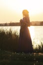 Romantic Silhouette Of Young Woman With A Violin At Dawn On River Bank, Elegant Girl Playing A Musical Instrument On Nature,