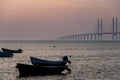 Sweden: Oresund Bridge detail at dusk with small boats. Profound deep link or bound illustration. Country boundaries or borders