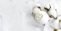 Romantic spa concept with bath bomb, cotton flowers on waved silk background. Luxury cosmetics branding.